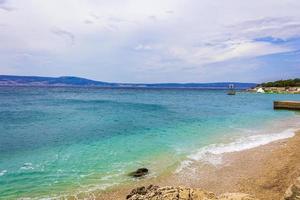 meravigliosa spiaggia di sabbia e rocce e lungomare novi vinodolski croazia. foto