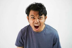 bello asiatico giovane uomo arrabbiato uomo urlando , urlando su forte isolato su bianca sfondo foto