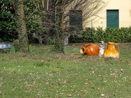 una statua di donna romana e antiche brocche di terracotta con manici foto