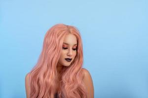 ritratto di bella donna con parrucca di capelli lunghi rosa e labbra scure