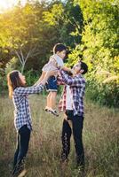 felice giovane famiglia che trascorre del tempo insieme all'esterno. concetto di amore familiare foto