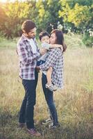 felice giovane famiglia che trascorre del tempo insieme all'esterno. concetto di amore familiare foto