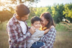 felice giovane famiglia che trascorre del tempo insieme all'esterno. concetto di amore familiare foto