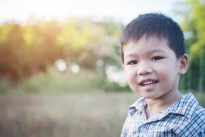 primo piano di un simpatico ragazzo asiatico che gioca e sorride all'aperto. foto