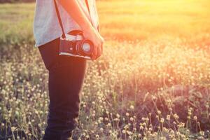 bello fotografo della giovane donna che tiene retro macchina fotografica di estate. foto