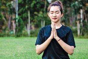 primo piano donna che medita e pratica yoga nella foresta foto