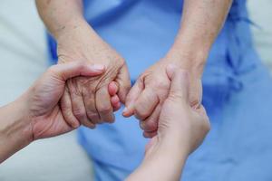 tenendo la mano donna anziana asiatica paziente con amore. foto