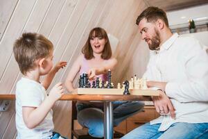 contento famiglia giocando scacchi nel il cucina foto