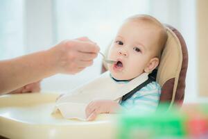 nonna dà bambino cibo a partire dal un' cucchiaio foto