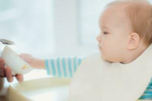 nonna dà bambino cibo a partire dal un' cucchiaio foto