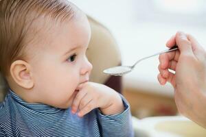 madre alimentazione sua bambino Seno porridge giorno foto