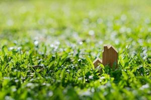 modello di casa in miniatura su sfondo di erba