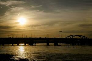 tramonto sagome su bin trieu ponte nel ho chi minh città foto