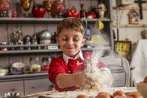 poco ragazzo avendo divertimento e preparare il Impasto per biscotti foto