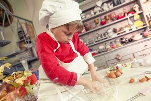 carino bambino nel il cucina mentre miscelazione il Impasto foto