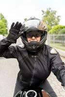 maturo donna nel motociclista capi di abbigliamento equitazione un' moderno motociclo all'aperto foto