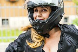 ritratto di maturo donna con motociclo casco all'aperto foto