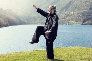 maturo uomo praticante tai chi disciplina all'aperto foto