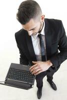 ritratto di giovane uomo d'affari con il computer portatile isolato su bianca sfondo foto