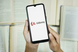 Tashkent, Uzbekistan - 27 giugno 2020 donna Tenere mobile Telefono con udemy logo su schermo foto