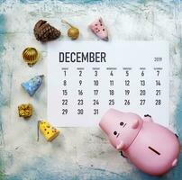 pianificazione il tuo Natale bilancio concetto. dicembre 2019 calendario con Natale giocattoli e porcellino banca foto