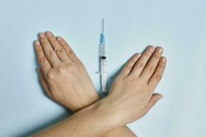 antivaxxer attraversamento mani vicino il siringa con covid-19 vaccino foto