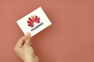 mano detiene un' carta con huawei logo foto