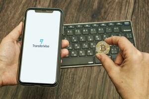 mano detiene un' smartphone con in termini di trasferimento logo e bitcoin foto