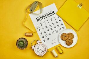 novembre calendario su luminosa giallo scrivania foto