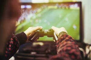 un' poco ragazzo giocando calcio su un' gioco consolle foto