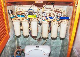 il sistema di purificazione di rubinetto acqua nel il appartamento. il processi di sostituzione il cartucce di un' multistadio acqua filtro. foto