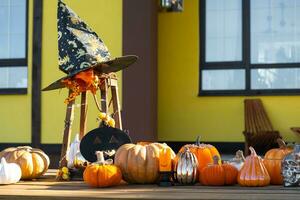 autunno arredamento su il veranda di il Casa al di fuori nel il cortile di zucca, lanterna, ghirlande, cappelli, Jack lanterna. Halloween festa, autunno umore, raccogliere Festival foto