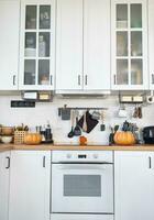 arredamento di il bianca classico cucina con zucche per Halloween e raccolto. autunno umore nel il casa interno, moderno soffitta stile. foto