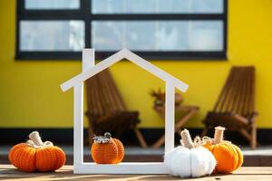 autunno arredamento su veranda di giallo Casa al di fuori di zucca, lanterna, ghirlande e figura di casa e chiave. Halloween festa, autunno umore, raccogliere Festival, vero proprietà, assicurazione, mutuo foto