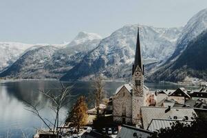 Hallstatt Cattedrale con alto montagne su il sfondo e blu cielo foto