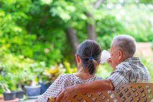 coppia di anziani seduti su una panchina e bevendo caffè al mattino a casa foto