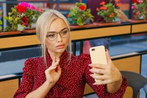 bellissimo donna seduta nel un' strada bar e parlando su il Telefono. foto