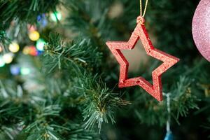 di legno Natale albero giocattolo nel il forma di un' stella sospeso su un' ramo, avvicinamento foto