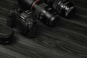 canone eos r fotocamera e montare adattatore ef - eos r con canone 105 millimetri f2.8 e sigma 24-105 f4 arte lenti a contatto su nero di legno tavolo foto