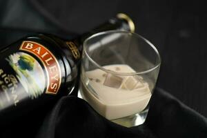 kiev, Ucraina - Maggio 4, 2022 baileys originale alcool bottiglia su di legno tavolo con nero tessuto foto