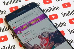 piace nastya video blog ufficiale Youtube canale su smartphone schermo su carta Youtube sfondo. foto