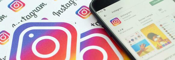 instagram App su Samsung smartphone schermo su bandiera con piccolo instagram loghi. instagram è americano foto e condivisione video sociale networking servizio di Facebook inc