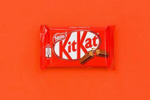 kit Kat cioccolato bar nel rosso involucro bugie su rosso sfondo. kit Kat creato di Rowntree di York nel unito regno e è adesso prodotta globalmente di annidarsi foto