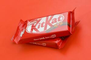 kit Kat cioccolato bar nel rosso involucro bugie su rosso sfondo. kit Kat creato di Rowntree di York nel unito regno e è adesso prodotta globalmente di annidarsi foto