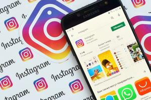 instagram App su Samsung smartphone schermo su bandiera con piccolo instagram loghi. instagram è americano foto e condivisione video sociale networking servizio di Facebook inc