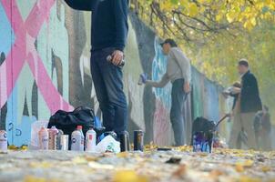 Kharkov, Ucraina - ottobre 19, 2019 Usato spray lattine per graffiti pittura di molti dipingere Marche all'aperto nel autunno foglie e artista nel pittura processi foto