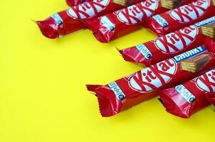 kit Kat cioccolato barre nel rosso involucro bugie su giallo sfondo. kit Kat creato di Rowntree di York nel unito regno e è adesso prodotta globalmente di annidarsi foto