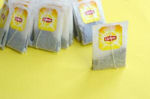 Lipton giallo etichetta nero tè borse su pastello giallo superficie vicino su. Lipton è un' mondo famoso marca di tè foto