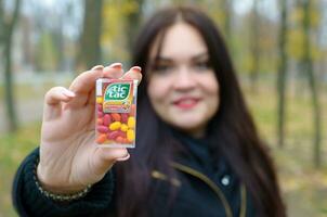 Kharkov, Ucraina - ottobre 26, 2019 giovane donna Spettacoli nuovo tic tac difficile zecche pacchetto nel autunno parco. tic tac è popolare dovuto suo menta fresco gusto di ferrero foto