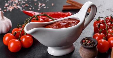 salsa rossa o ketchup in una ciotola e ingredienti per cucinare foto